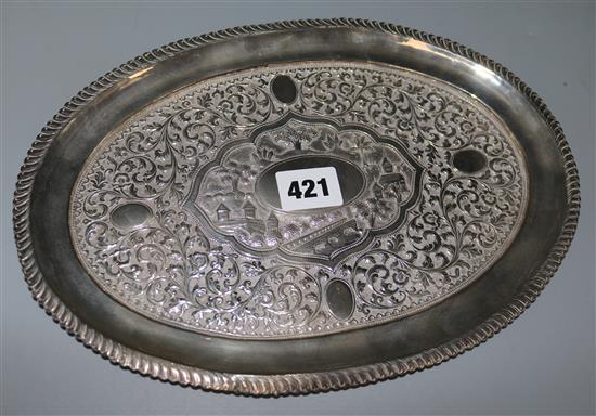 An Indian silver oval tray embossed with scrolls and village scene, 9 oz.